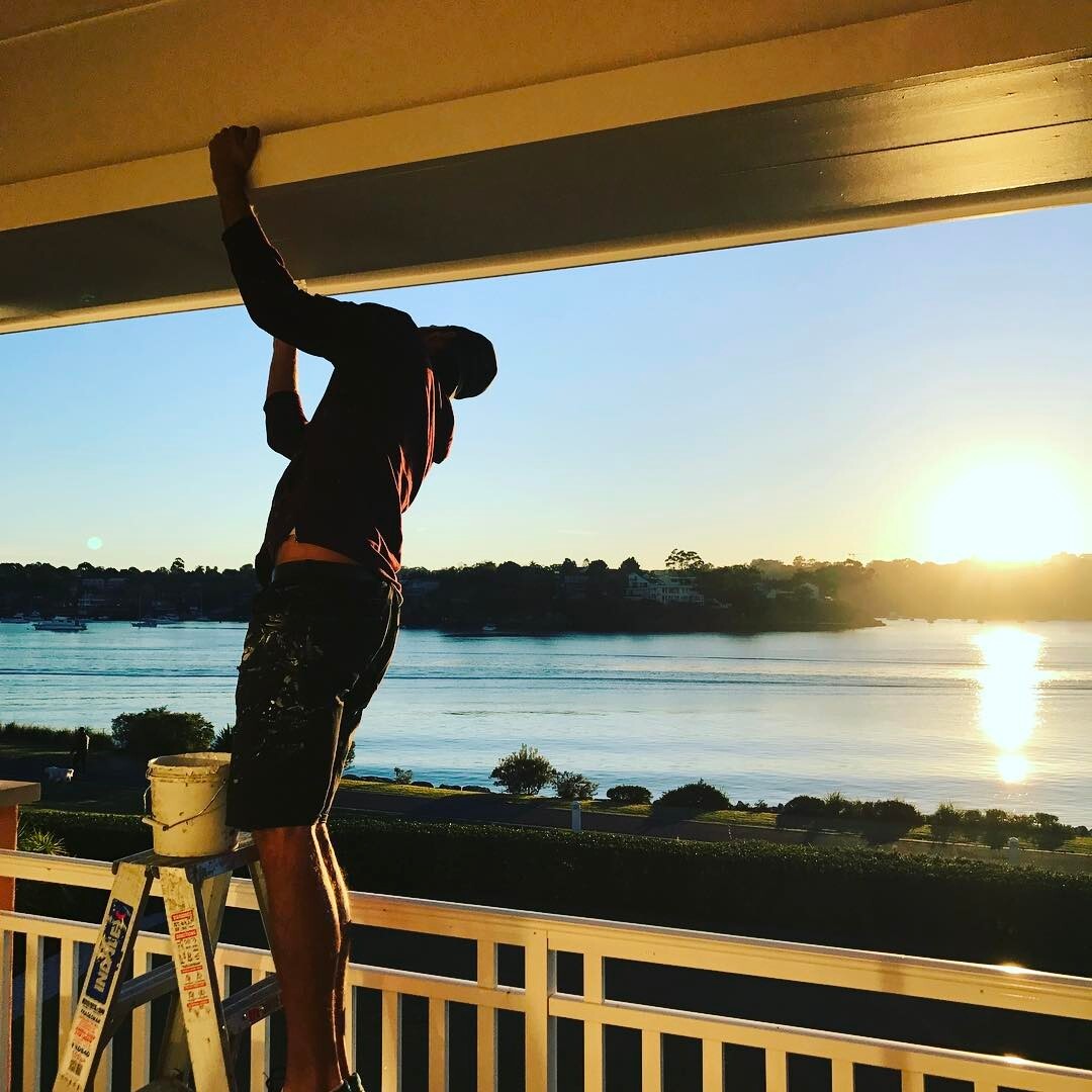 MrPaint painter working on a waterfront balcony at sunset in Trinity Beach, Cairns