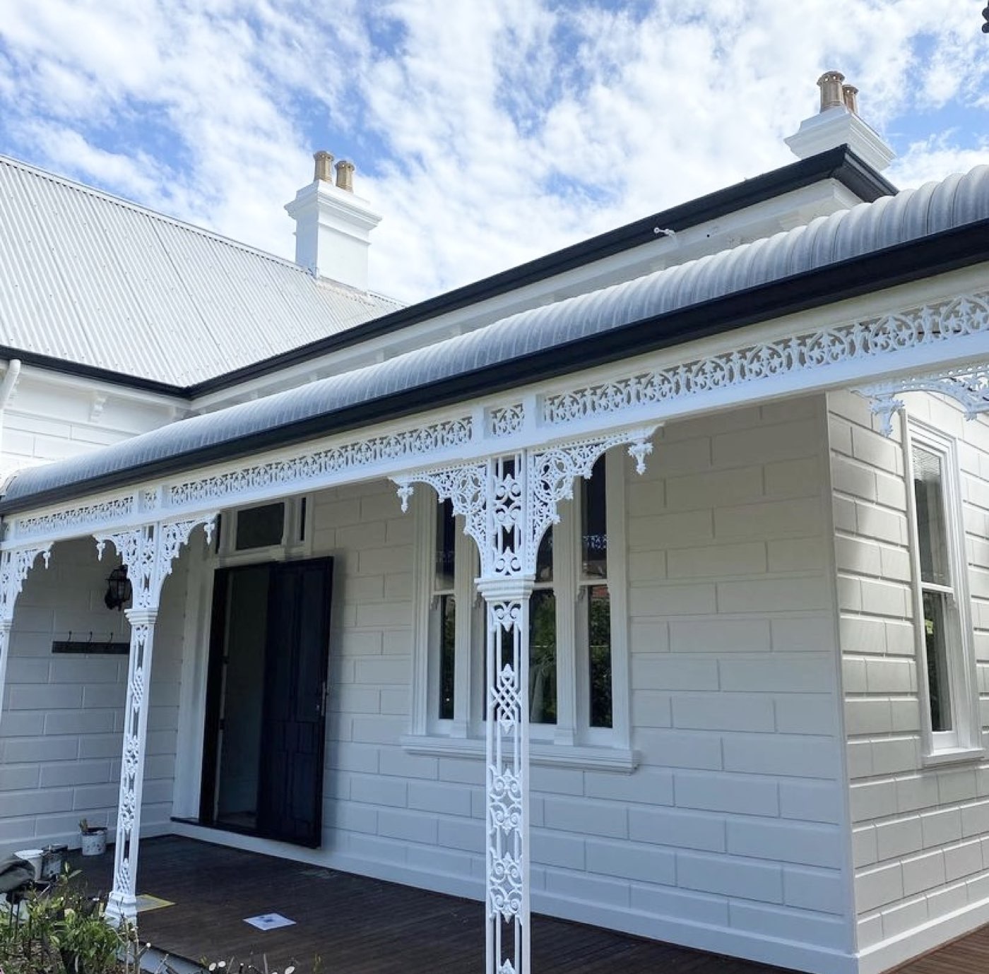 Restored heritage home with intricate white verandah lacework