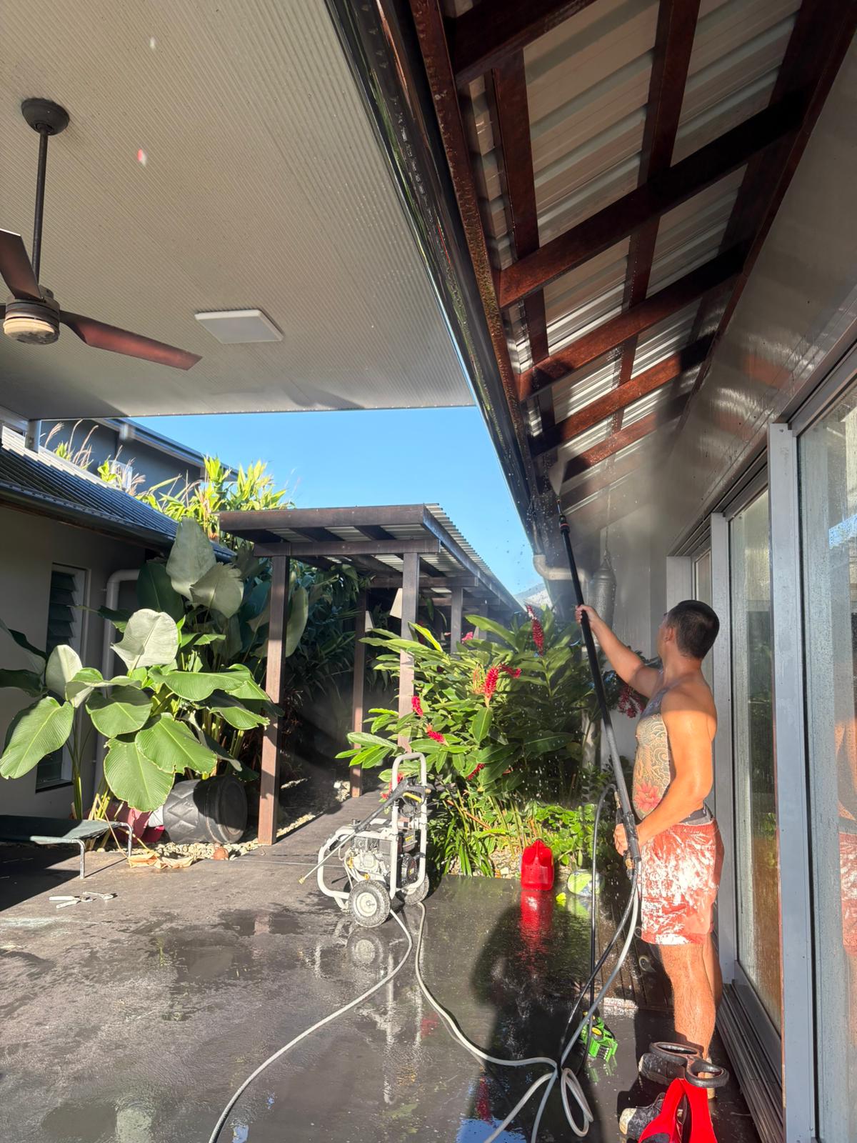 Pressure washing eaves on a Balinese-style bungalow